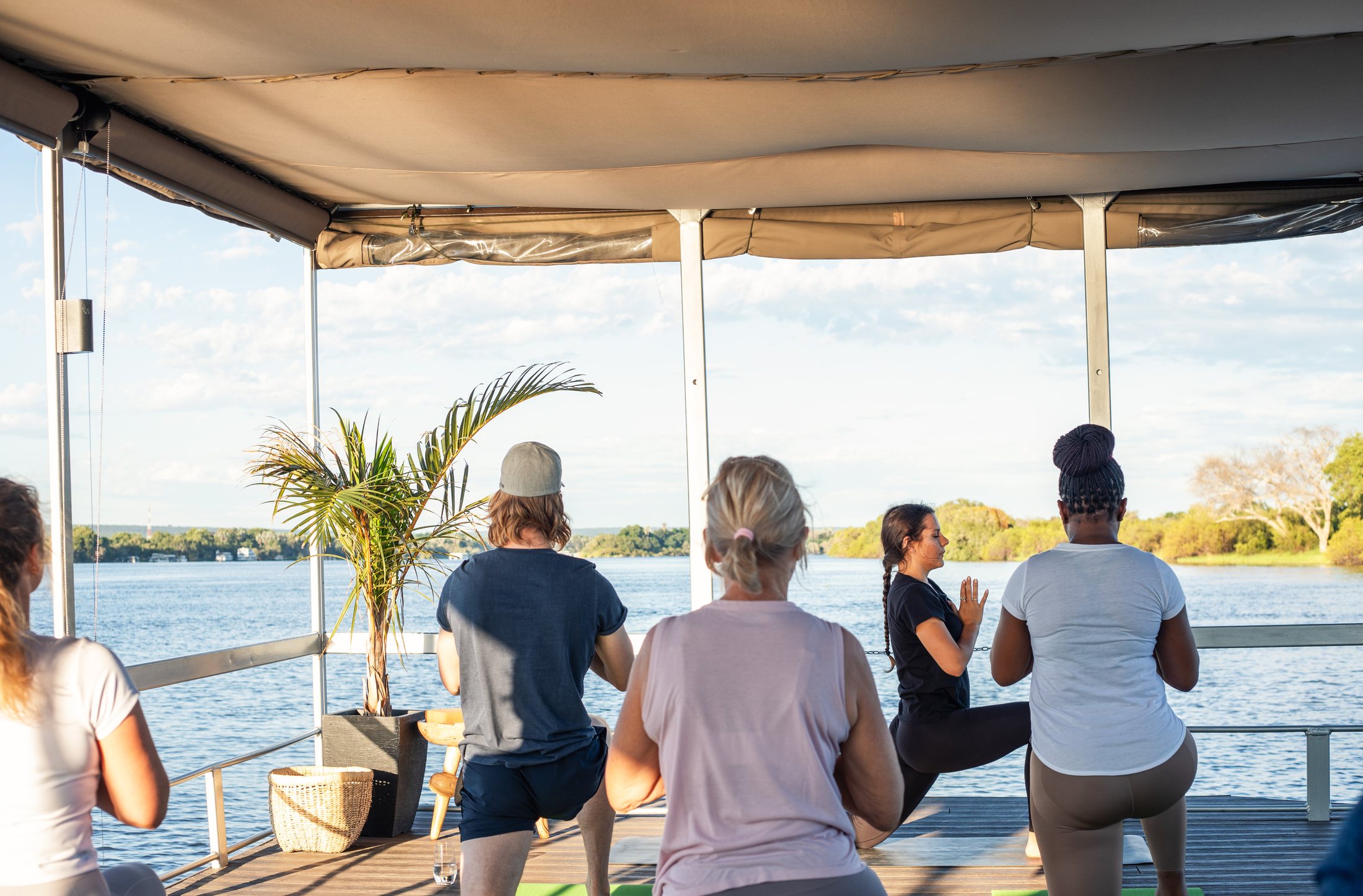 Group meditation on a deck overlooking the Zambezi River at sunrise